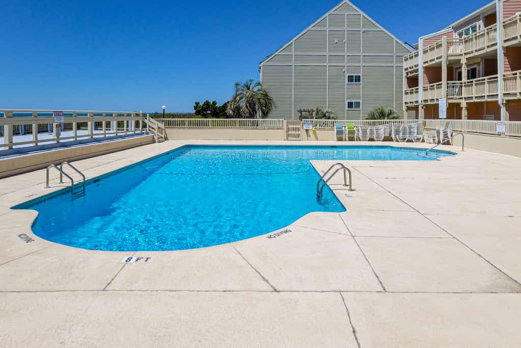 Updated third-floor condo with WiFi, shared pool, balcony, W/D, & central AC