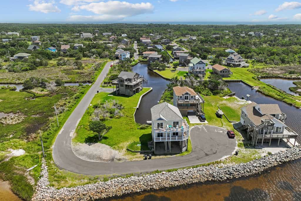 Waterfront home with boat dock, shared pool, & balcony with ocean view