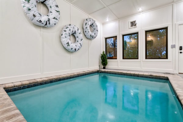 Your perfect retreat for family vacations or group getaways awaits! Enjoy a private indoor heated pool, a game loft, an outdoor hot tub, and multiple decks with cozy seating. Inside, unwind by the indoor fireplace, cook in a fully stocked kitchen with modern appliances, and relax in luxurious bedrooms and spa-inspired bathrooms. Guests also have access to a community pickleball court for a fun and active outdoor experience during your stay. Fast WiFi and room for up to 10 guests.