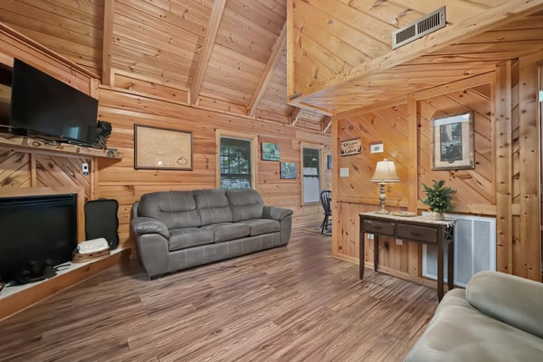 Relax in a cozy 2-bedroom Gatlinburg cabin near the Arts & Crafts Community, featuring a private hot tub, deck, wood-burning fireplace, and full kitchen. Enjoy convenient access to Downtown Gatlinburg, Great Smoky Mountains National Park, Anakeesta, Ripley’s Aquarium, and Rocky Top Sports World. A comfortable getaway for couples, families, and small groups.