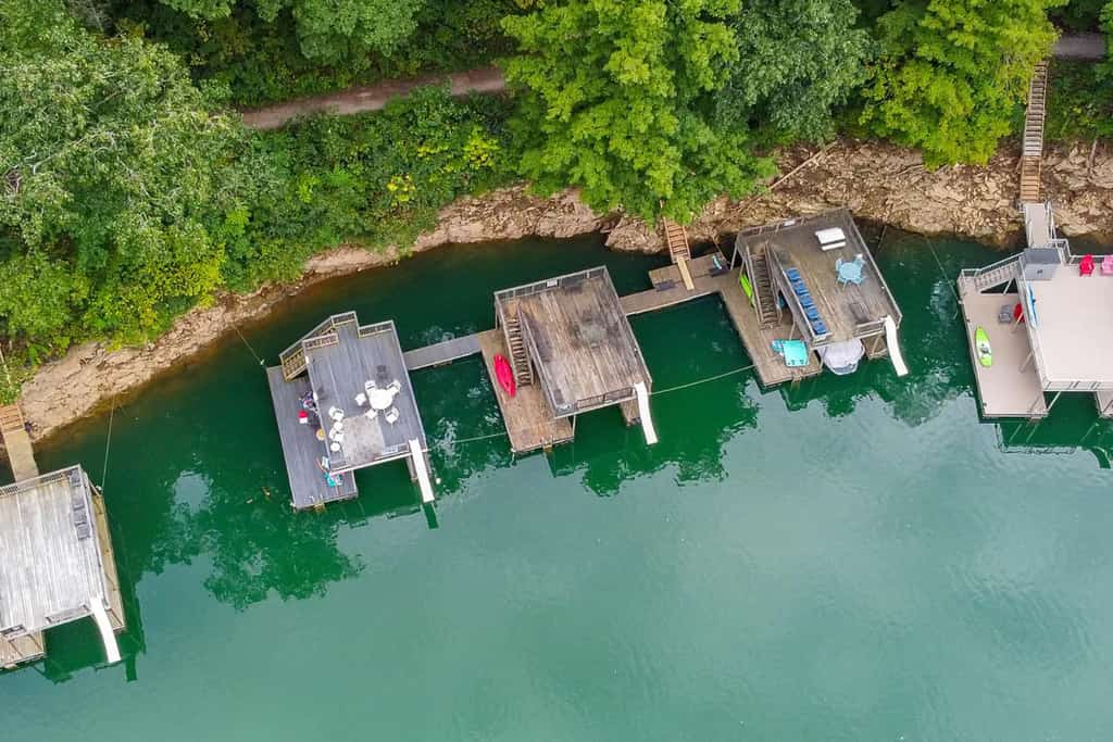 Luxury 8-bedroom, 8-bathroom cabin in LaFollette, Tennessee, featuring panoramic Norris Lake and mountain views, a seasonal private double-decker dock with slide, hot tub, game room, and home theater. Located in gated Lakeside Estates with access to a community pool, boat ramp, and walking trails. Ideal for family reunions, multi-family vacations, and large group getaways.