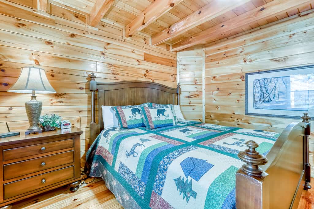 A bedroom with a bed, dresser, and window