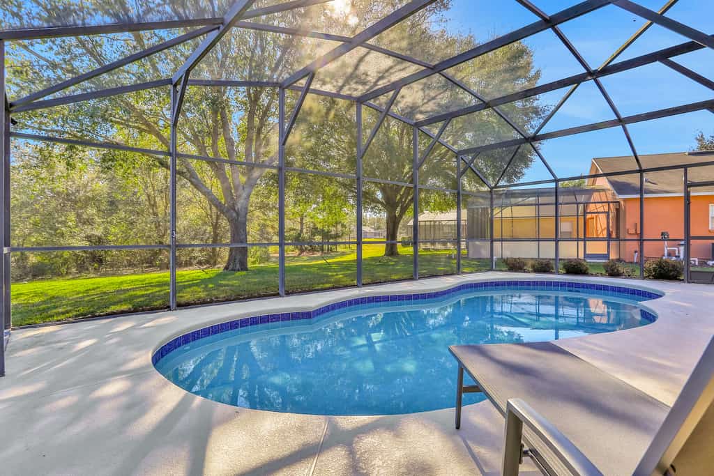 Peaceful home with an enclosed patio, pool, grill, washer/dryer, & AC