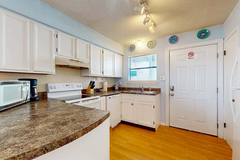 Waterfront condo with a furnished balcony, peek-a-boo Gulf views, & shared pools