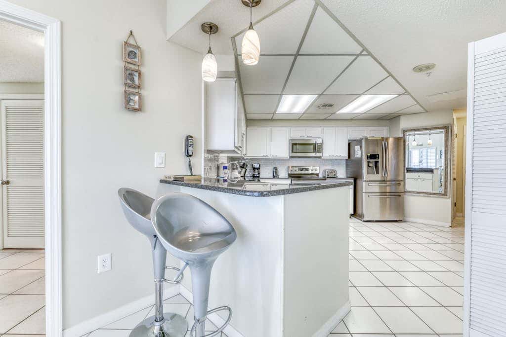 Waterfront corner condo with shared pools, wrap-around balcony, & tennis courts