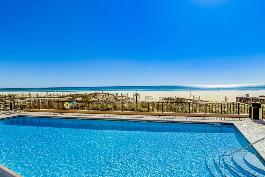 Waterfront corner condo with shared pools, wrap-around balcony, & tennis courts