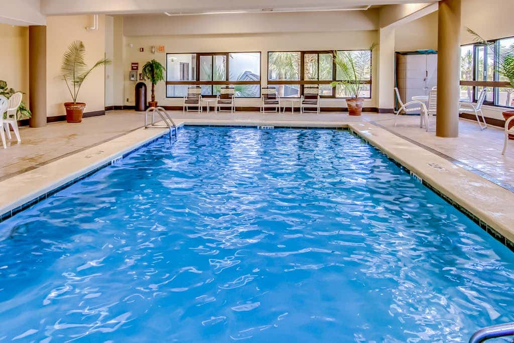 Waterfront corner condo with shared pools, wrap-around balcony, & tennis courts