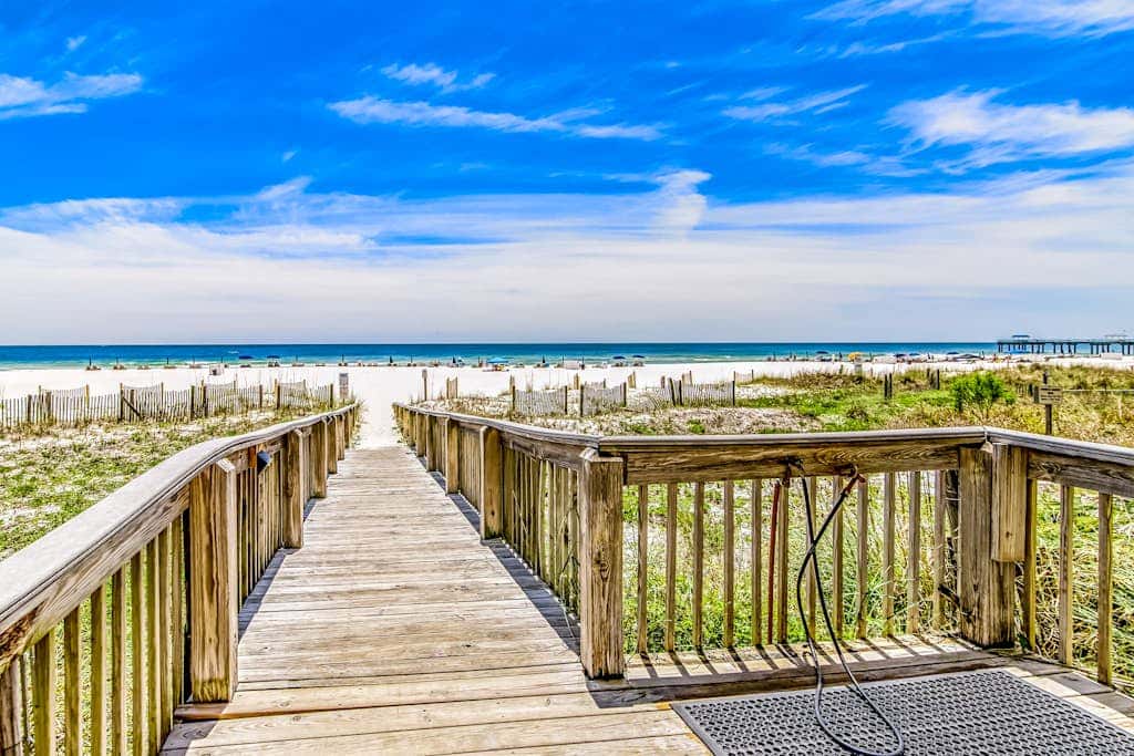 Waterfront corner condo with shared pools, wrap-around balcony, & tennis courts