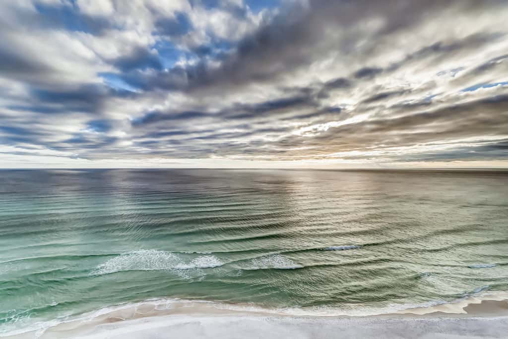 Serene & upscale beachfront condo with furnished balcony, view, & pools