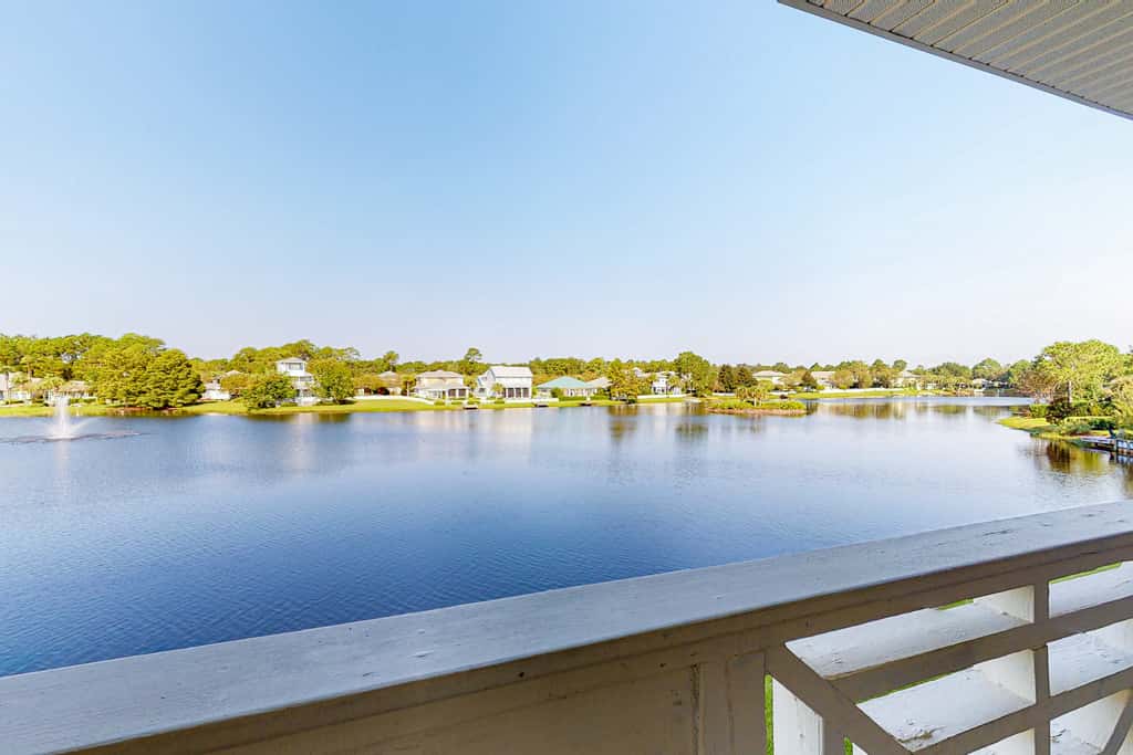 Lakefront condo with water-view balcony, private golf cart, resort pool & amenities