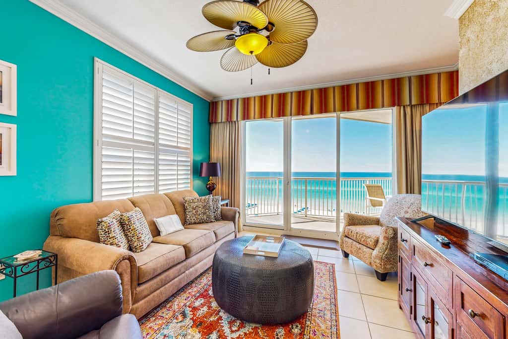 Beachfront condo with beach chairs, an umbrella, and a pool