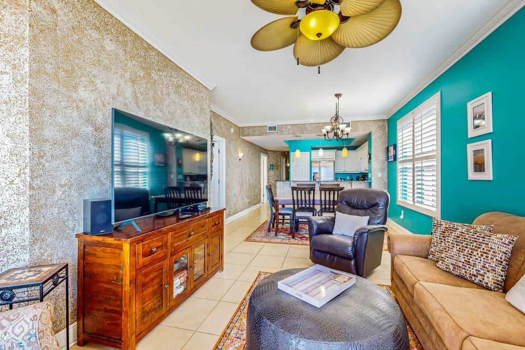 Beachfront condo with beach chairs, an umbrella, and a pool