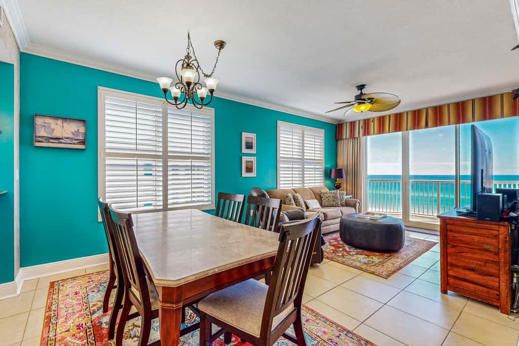 Beachfront condo with beach chairs, an umbrella, and a pool