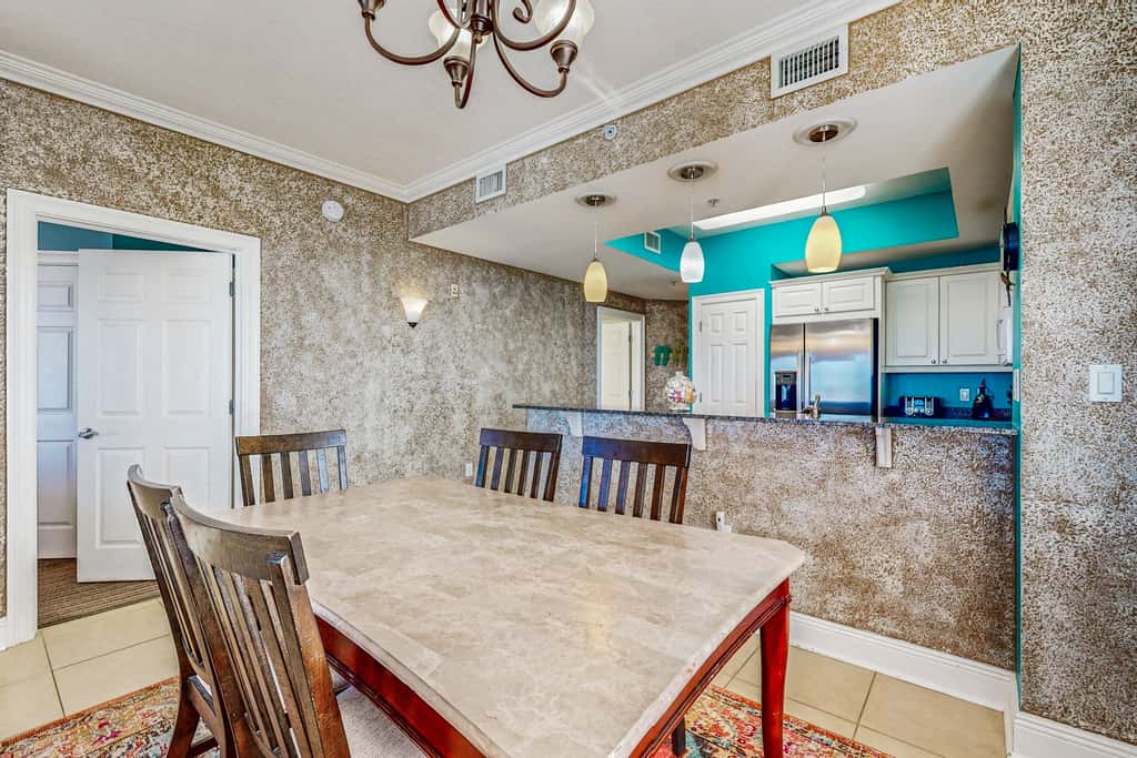 Beachfront condo with beach chairs, an umbrella, and a pool