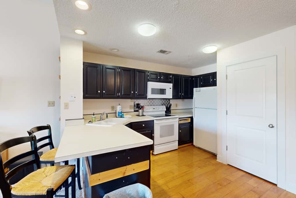 Comfortable townhome steps from beach with pool access, balcony, & WD