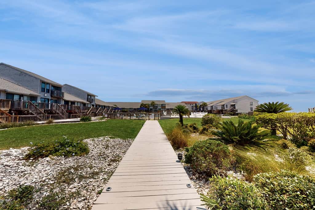 Comfortable townhome steps from beach with pool access, balcony, & WD