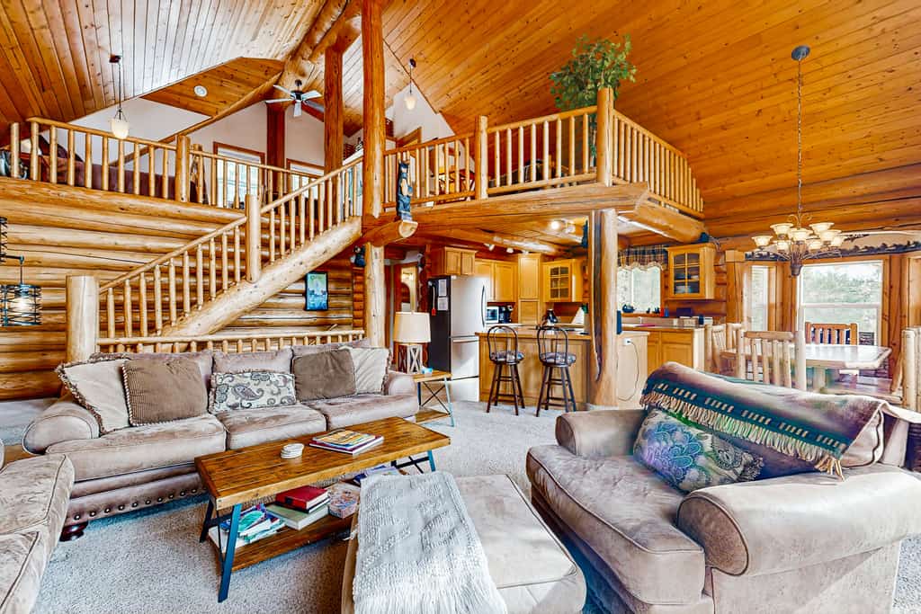 A spacious lake-view log cabin with two living areas, a large deck, fire pit, and pool table. Surrounded by mountain scenery near Lake Cascade, this comfortable retreat features oversized windows, wood-burning fireplaces, air conditioning, outdoor gathering spaces, and room for families and groups to relax in every season.