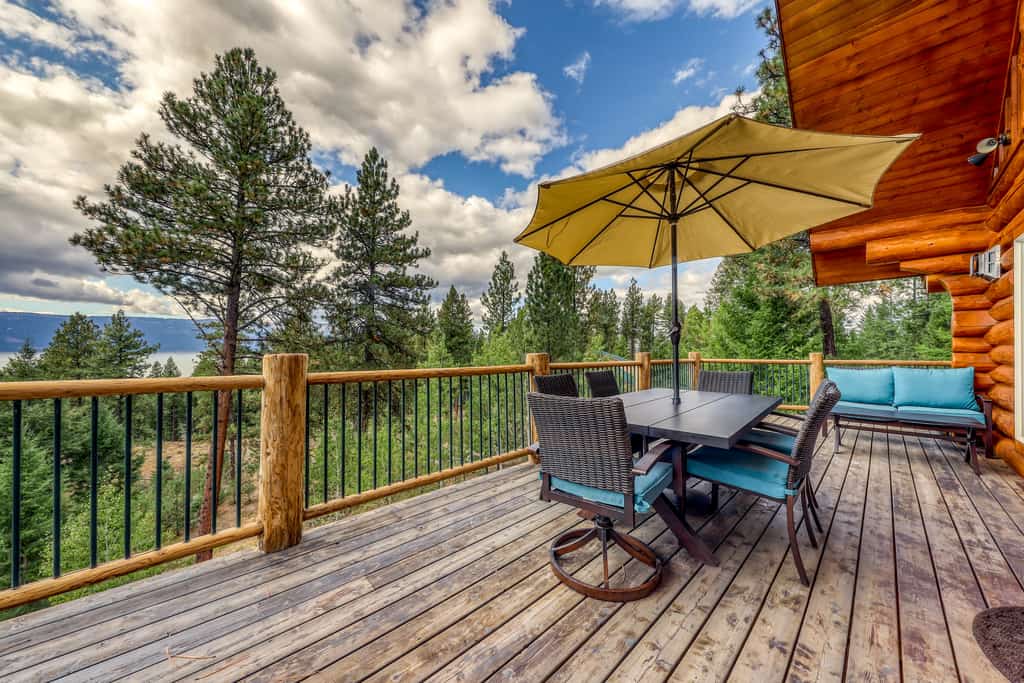 A spacious lake-view log cabin with two living areas, a large deck, fire pit, and pool table. Surrounded by mountain scenery near Lake Cascade, this comfortable retreat features oversized windows, wood-burning fireplaces, air conditioning, outdoor gathering spaces, and room for families and groups to relax in every season.