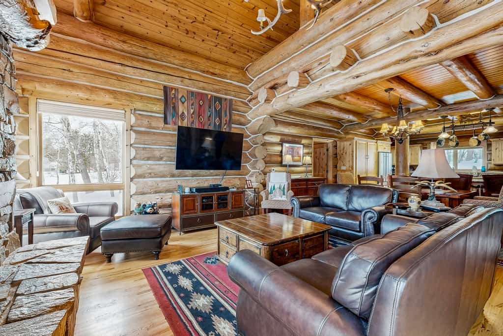 A custom-built log cabin surrounded by aspens with sweeping countryside views, a private hot tub, and a lodge-style great room. Featuring a gourmet kitchen, stone fireplace, covered patio, loft sleeping area, and game space in the garage, this mountain retreat offers a peaceful setting with room for families and small groups to relax year-round.