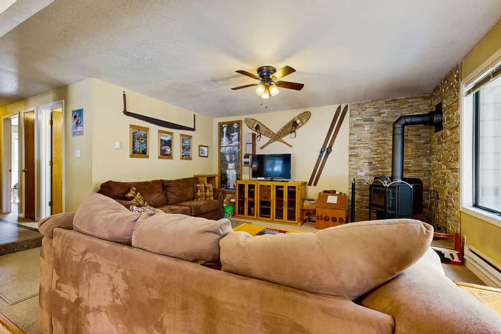 A bright end-unit condo in Aspen Village with wooded views, thoughtful mountain decor, and access to resort-style community amenities including pools, hot tub, sauna, fitness center, and sports courts. Featuring two king suites, oversized living room seating, a wood-burning fireplace, and easy access to downtown McCall and Payette Lake, this comfortable retreat is ideal for relaxing mountain getaways year-round.