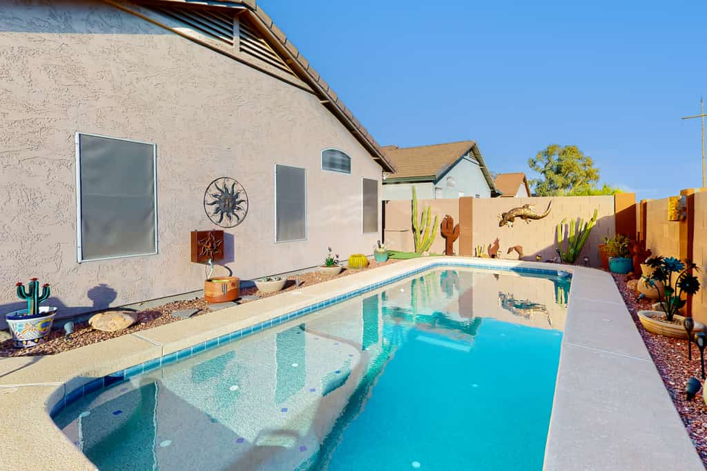 Southwestern home with colorful patio, sparkling pool, grill & dart board