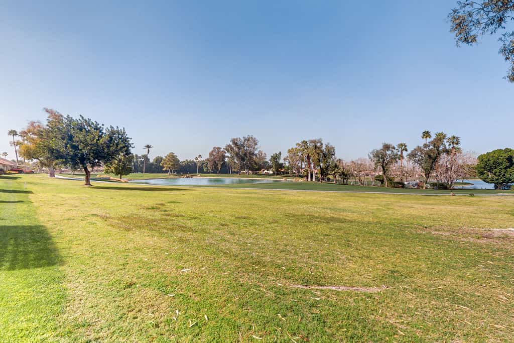 Water-view home on golf course with hot tub, pool, tennis, on-site golf, & patio