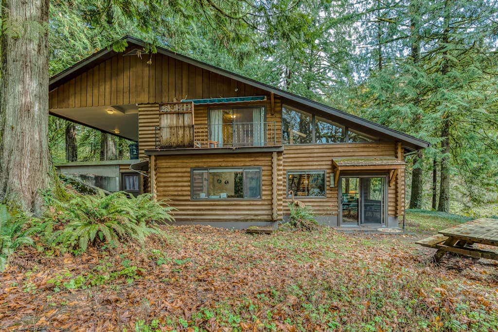 Spacious riverfront lodge with beach access, private hot tub & forest views