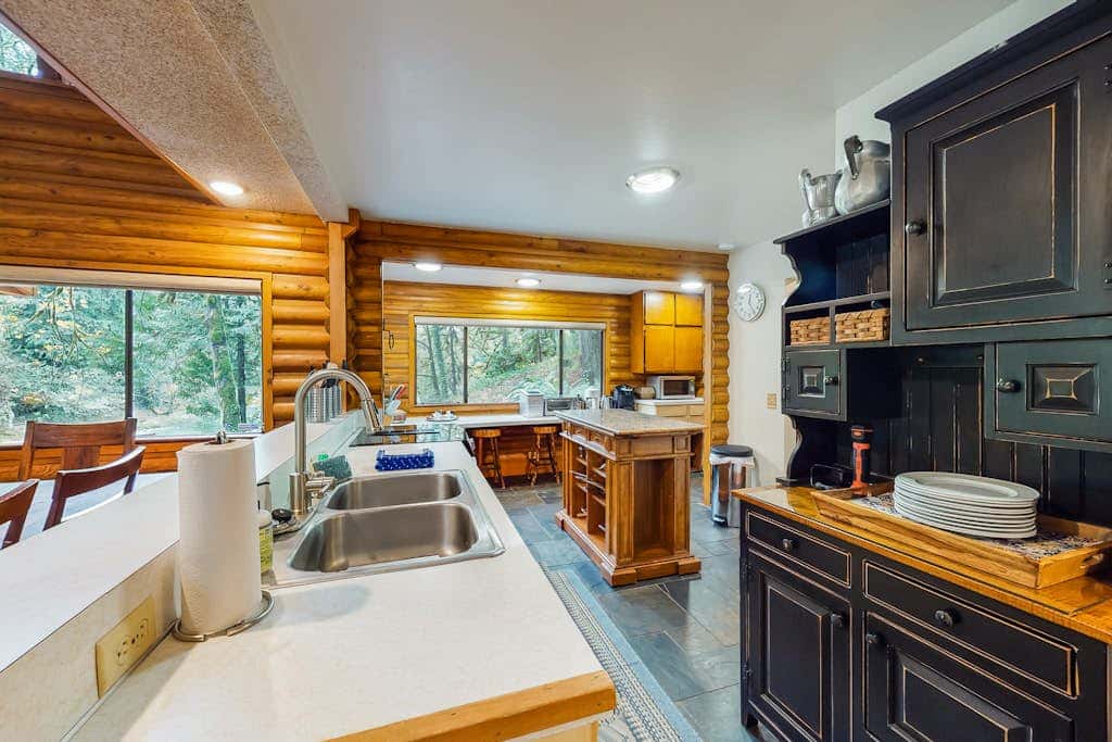 Spacious riverfront lodge with beach access, private hot tub & forest views