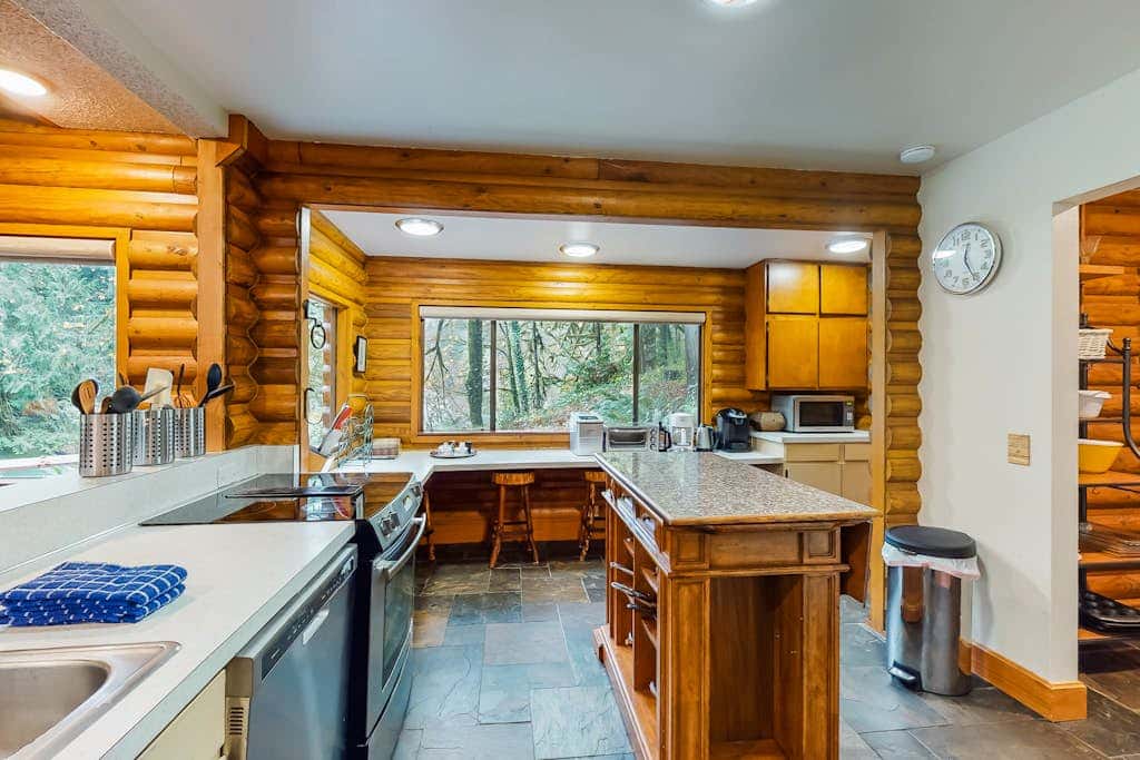Spacious riverfront lodge with beach access, private hot tub & forest views