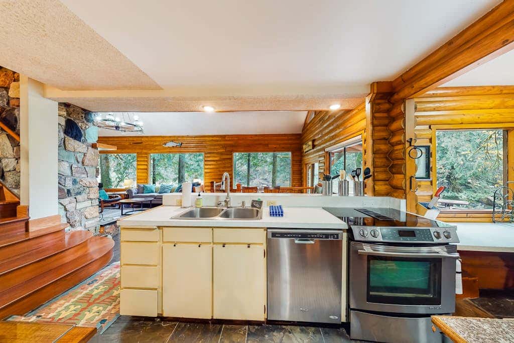 Spacious riverfront lodge with beach access, private hot tub & forest views
