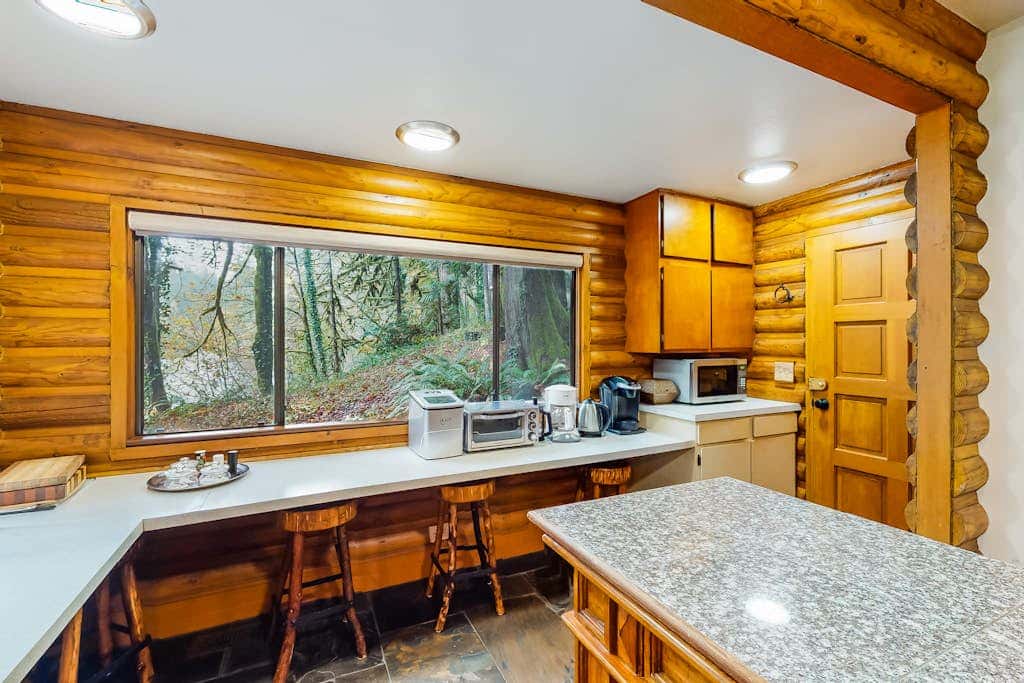 Spacious riverfront lodge with beach access, private hot tub & forest views