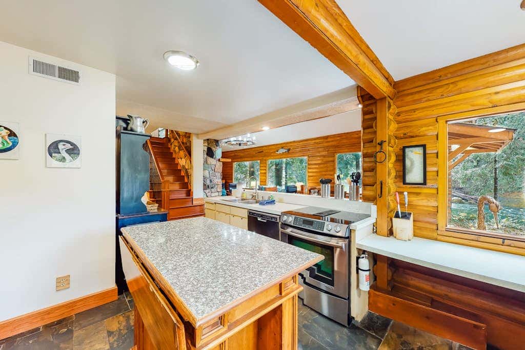Spacious riverfront lodge with beach access, private hot tub & forest views