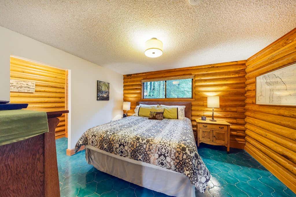 Spacious riverfront lodge with beach access, private hot tub & forest views