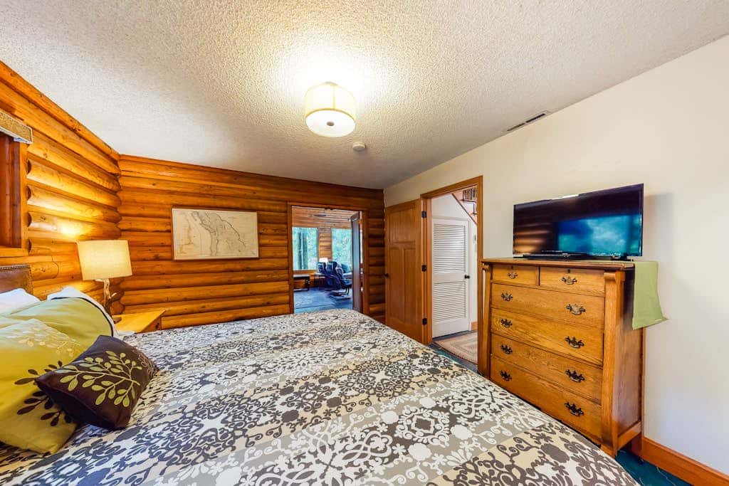 Spacious riverfront lodge with beach access, private hot tub & forest views