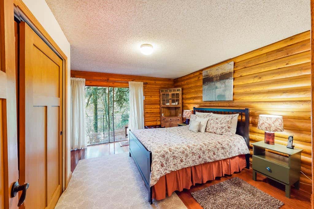 Spacious riverfront lodge with beach access, private hot tub & forest views