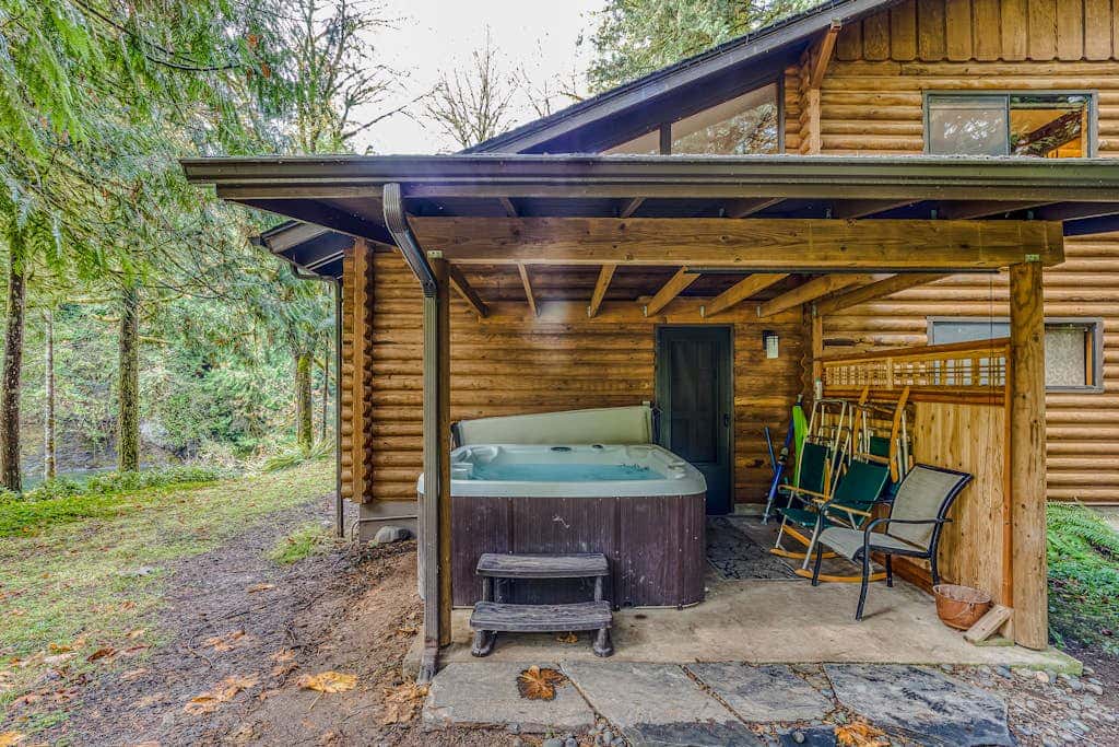 Spacious riverfront lodge with beach access, private hot tub & forest views