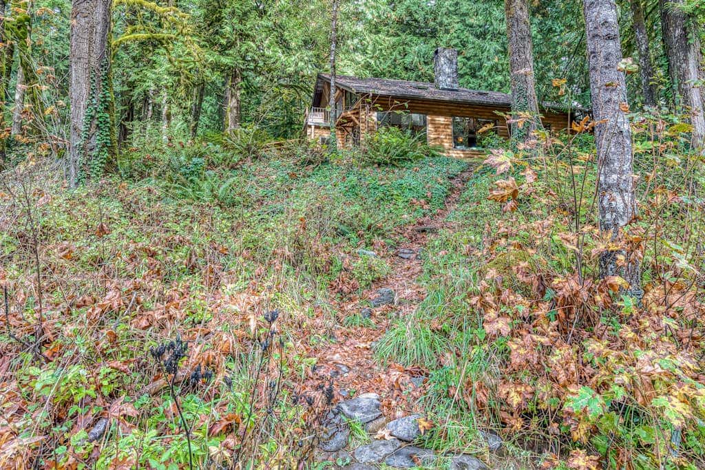 Spacious riverfront lodge with beach access, private hot tub & forest views