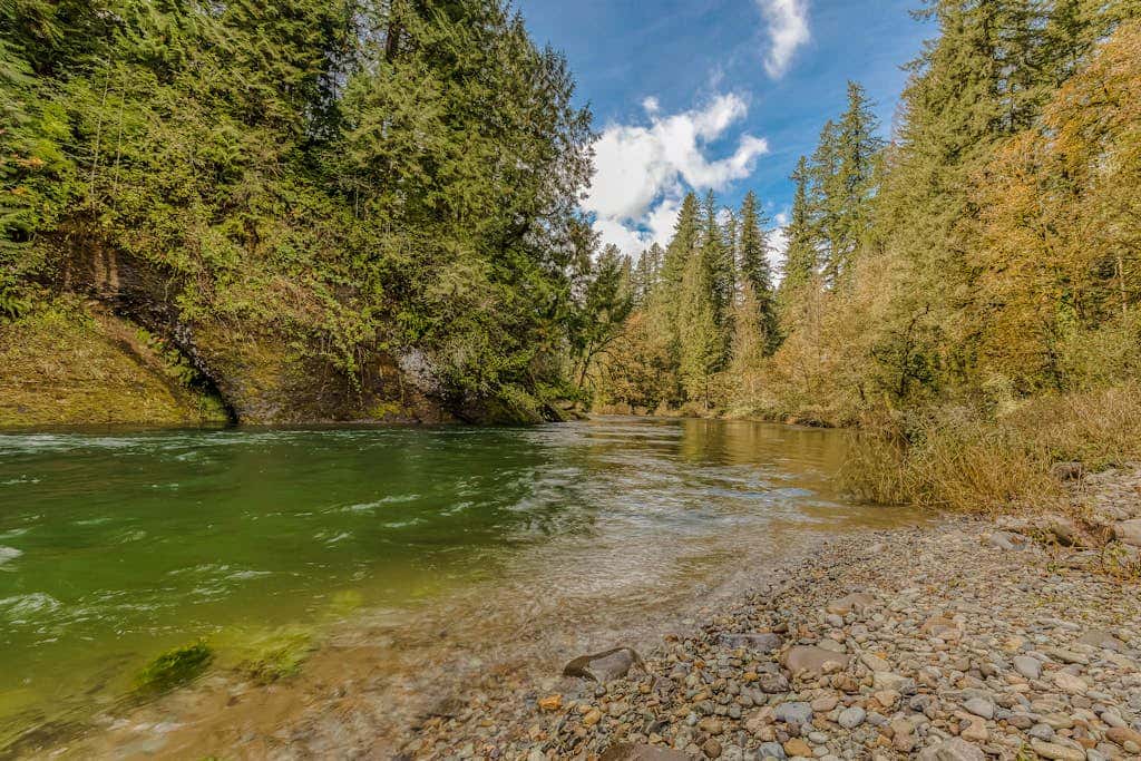 Spacious riverfront lodge with beach access, private hot tub & forest views