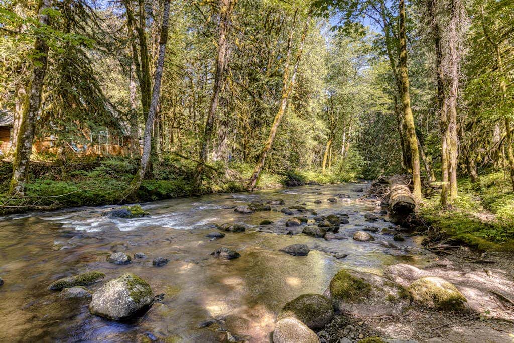 Classic riverfront home with great views, game room, hot tub, & modern cabin feel