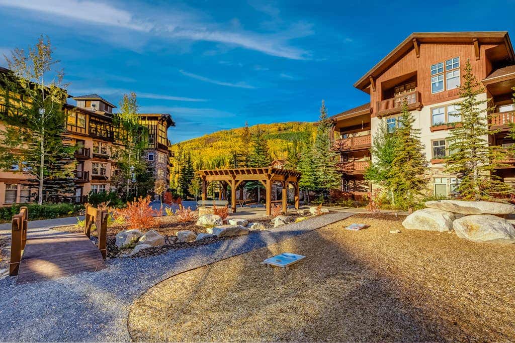 ski-in - ski-out condo with a deck, ski views & a shared pool and hot tub