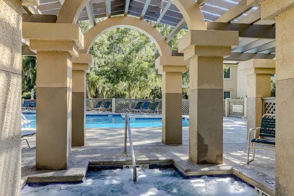 Sun-kissed bliss at Colonnade Club with dual suites, deck, shared pool, hot tub