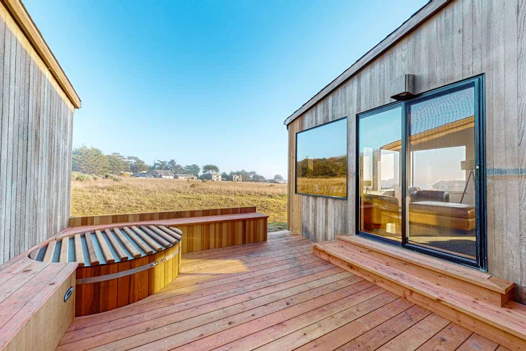 The Pacific shimmers in the distance as you unwind in this Sea Ranch retreat. End the day in your private hot tub with the ocean as your soundtrack. Bring your pup -- dogs love the bluff trails here. Room for 6 in this 2-bedroom home. Just a 10-minute walk to the heated community pool. Trails, tidepools, and two heated community pools -- all within reach. Watch the fog roll in from the deck as the coastline disappears and reappears like magic.