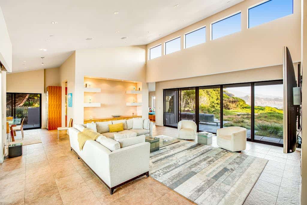 Out where the road ends and the bluff takes over, this home is nearly surrounded by ocean — and every single room has a view of it. The living room is wrapped in floor-to-ceiling sliding glass on two sides, with ocean views out both — waves to the north over Smugglers Cove, waves to the south toward Black Point. Whale spouts from the sofa, waves from your pillow, fog with your coffee. Sleeps 6 in 3 bedrooms, a 7-minute walk to Pebble Beach. The only agenda here is yours.