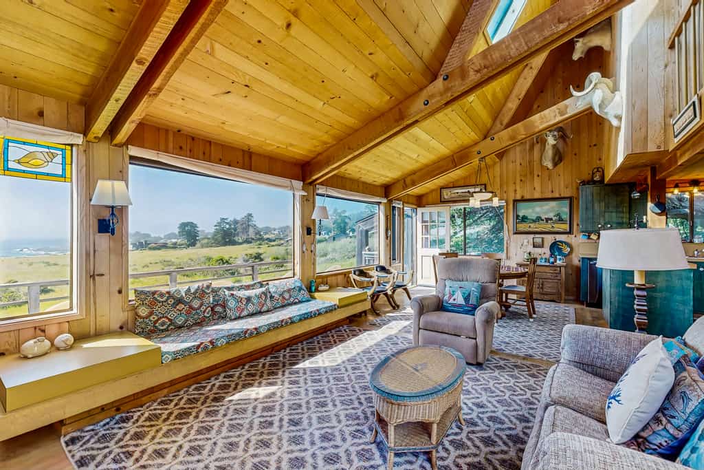 Built on a rock outcropping above the Sea Ranch commons, this three-bedroom home looks straight out at white water near Pebble Beach — and it welcomes two dogs. Inside, wood walls climb to vaulted ceilings, a wood stove takes the edge off foggy evenings, and a handmade quilt waits on every bed. Decks on both sides of the house; sleeps 6. The south rec center pool is a 10-minute walk, the Pebble Beach trail under 15, and Gualala's groceries and galleries are 10 minutes north on Highway 1.