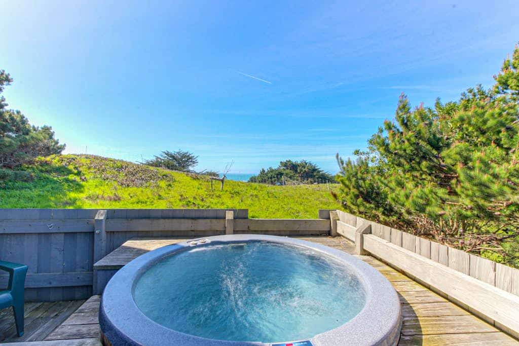 Wake to ocean views and the call of seabirds in this light-filled coastal home. End the day in your private hot tub with the ocean as your soundtrack. Step outside to a deck overlooking the ocean. Room for 6 in this 3-bedroom home. A short walk from Pebble Beach. Miles of bluff-top trails and hidden beaches are yours to explore. Hear the surf from your pillow and watch the waves from your coffee spot. Pack layers -- mornings start with fog, afternoons warm to sun, and evenings glow at sunset.