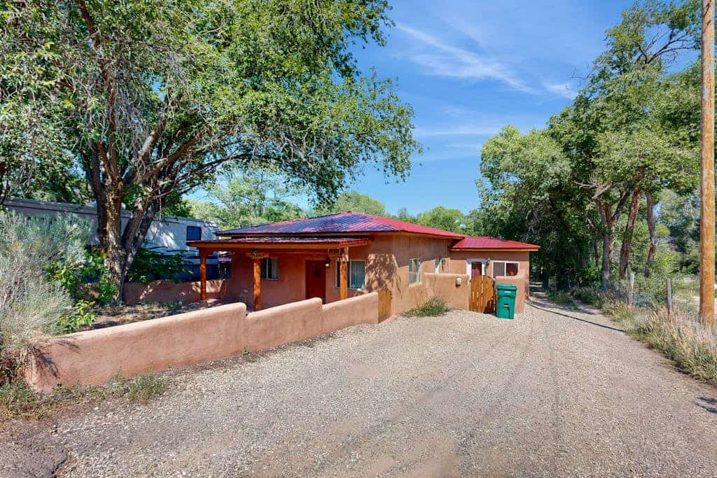Welcome to Two Sisters Adobe, a beautifully updated single-level adobe just steps from the heart of Taos. Wake to soft light through wood-beam ceilings, cook in a granite chef's kitchen, and wander under half a mile to the Plaza's shops and restaurants. Come home to unwind in a spa-style steam shower, grill dinner in the private walled yard, and linger on the softly lit back deck beneath the high-desert sky. It's an easy, welcoming home base for everything Taos has to offer