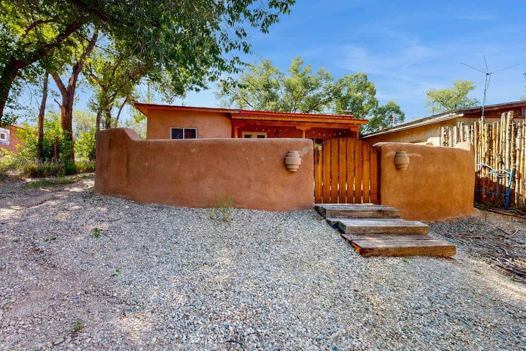 Welcome to Two Sisters Adobe, a beautifully updated single-level adobe just steps from the heart of Taos. Wake to soft light through wood-beam ceilings, cook in a granite chef's kitchen, and wander under half a mile to the Plaza's shops and restaurants. Come home to unwind in a spa-style steam shower, grill dinner in the private walled yard, and linger on the softly lit back deck beneath the high-desert sky. It's an easy, welcoming home base for everything Taos has to offer