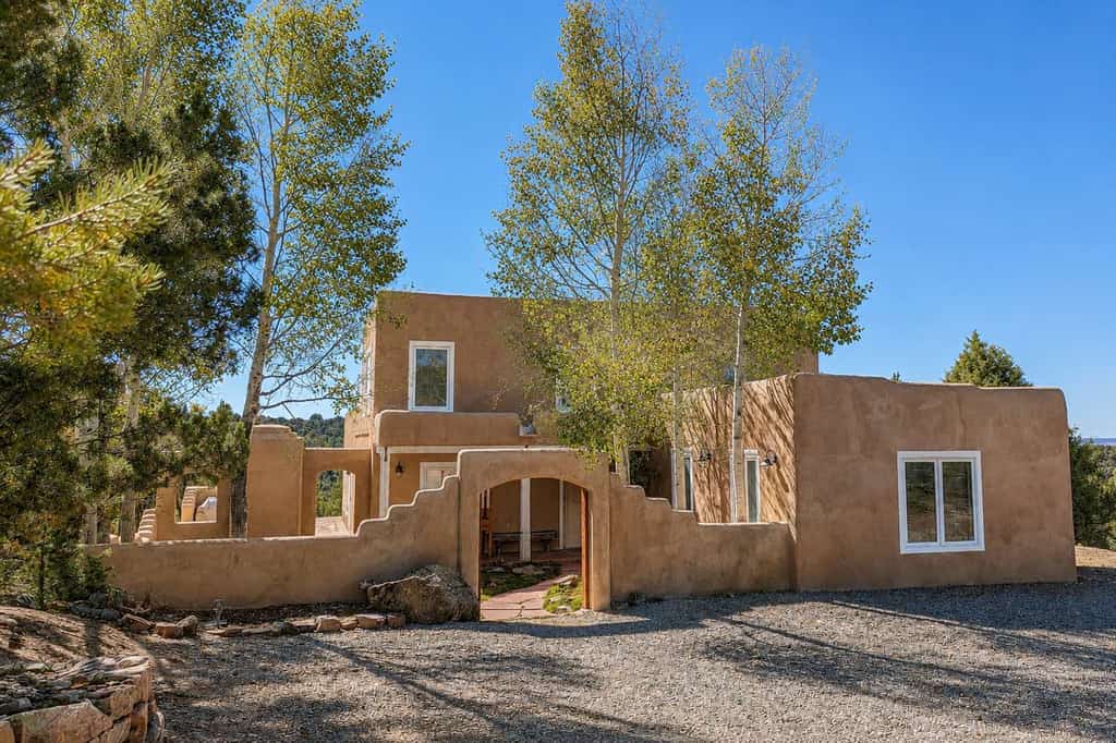 Welcome to Pueblo de Canoncito, an elegant Southwestern retreat on 11 private acres bordering national forest just outside Taos. Pueblo-inspired architecture, saltillo tile, and timber ceilings set a serene tone, while a walled courtyard and forest-view patio with a kiva-style outdoor fireplace invite slow mornings and starlit evenings. Cook in the full kitchen, warm up by the wood-burning fireplace, and let your dog roam. With room for nine, it's a peaceful, scenic basecamp.