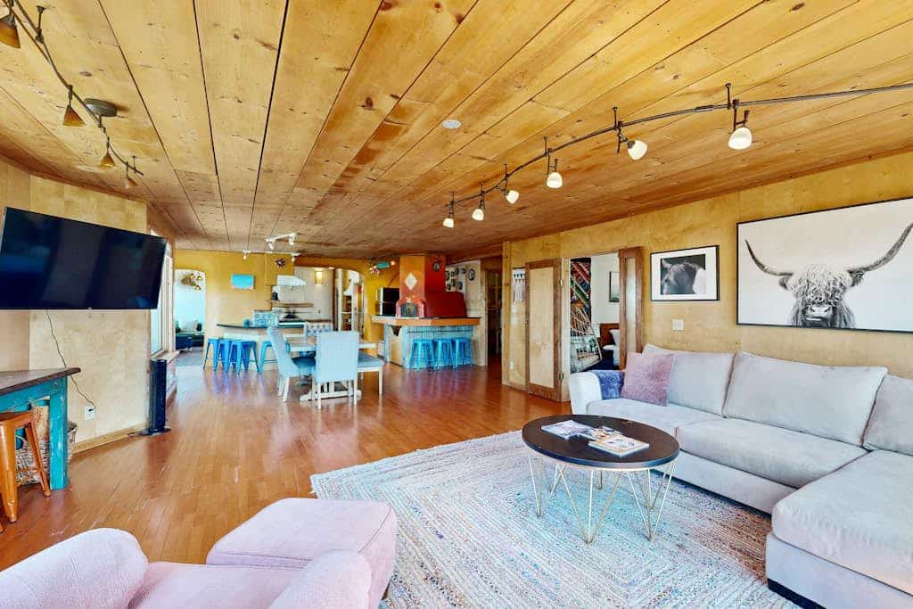 Tucked behind a private gate on a pinon-dotted mesa between Taos and Taos Ski Valley, this one-of-a-kind adobe hideaway is built for slow mornings and long mountain views. Cook in a kitchen built around a showpiece pizza oven, gather by the kiva fireplace, and unwind in the spa-like primary suite. Two living areas, three bedrooms, and walls of glass framing the Sangre de Cristos make easy room for nine - and the dogs are welcome too. Peace, pizza, and big New Mexico sky await.
