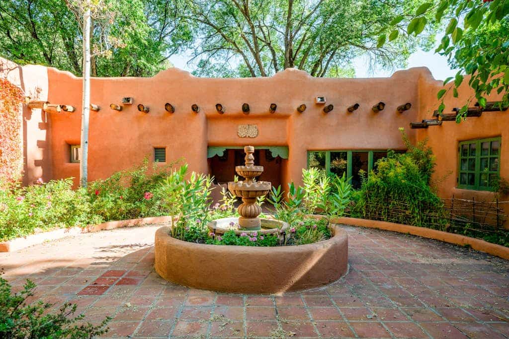 Escape to Casa Rosa, a sun-drenched 1916 adobe estate on more than two acres of historic gardens just minutes from Taos. Wander brick courtyards past a tiled fountain, soak in the private hot tub under the cottonwoods, and gather by the kiva fireplace as evening falls. With five bedrooms, four baths, a vibrant tiled kitchen, and a sunlit library, there is room for everyone to spread out, slow down, and reconnect.